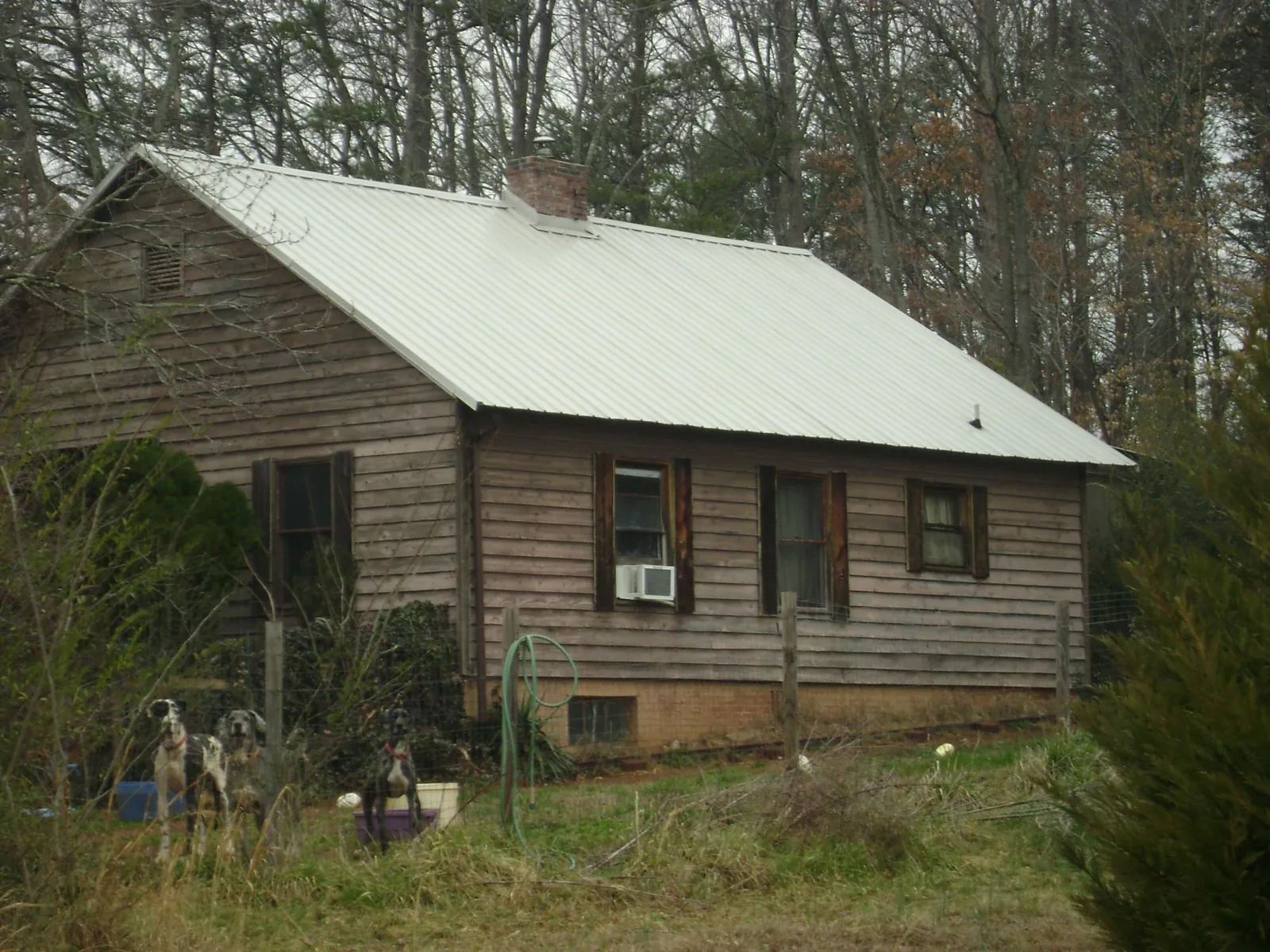 White metal roof on an old wood sided farmhouse, from a Metal Roof Installation job in Albia